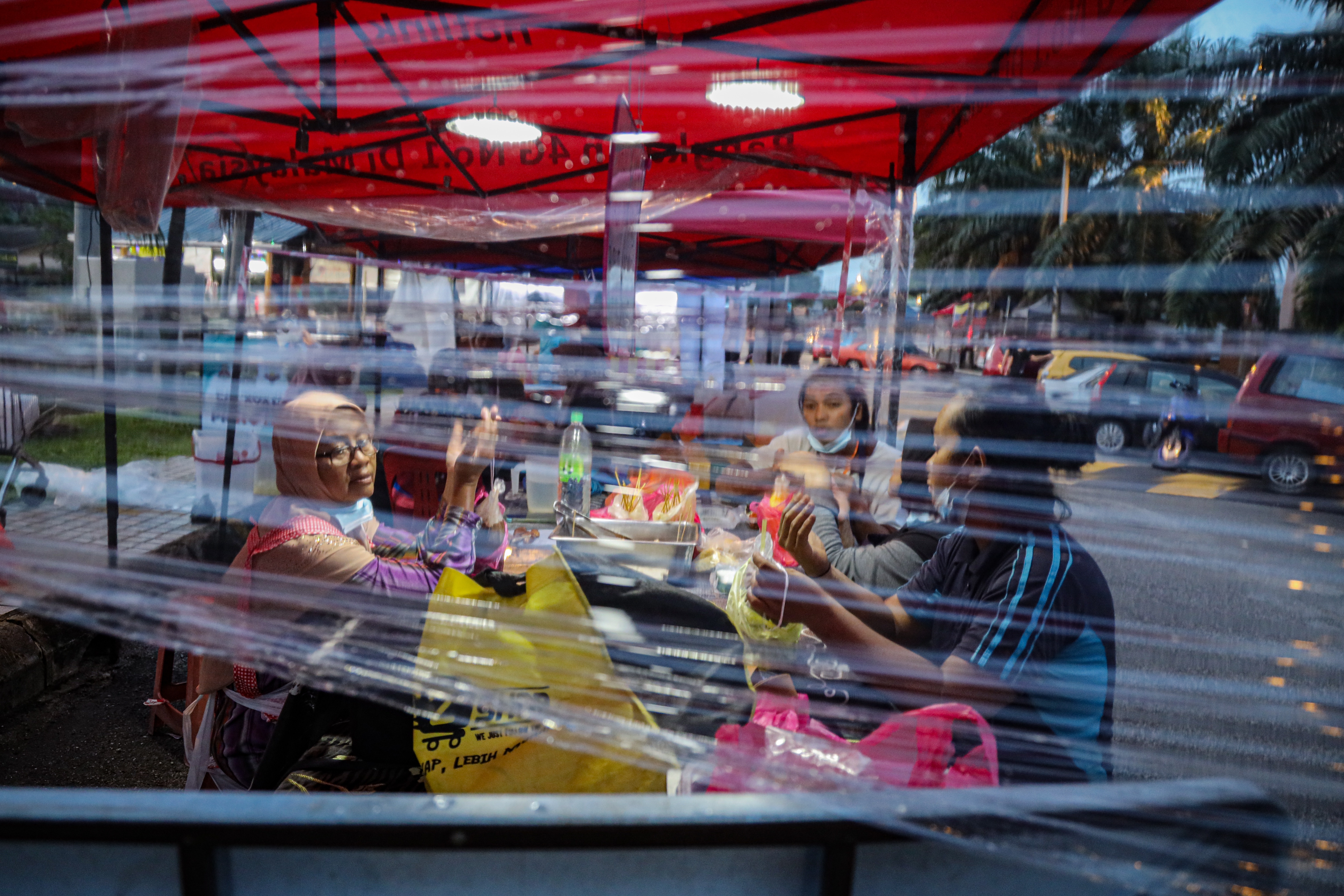 Muslim vendors pray in their Ramadan bazaar stall ahead of iftar in Kuala Lumpur, Malaysia. Photo: Annice Lyn/Getty Images