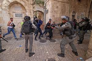 Palestinian protesters run from Israeli security forces.
