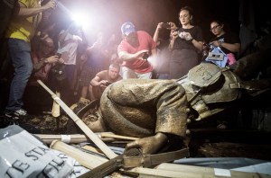 Demonstrators and spectators gather around a toppled Confederate statue known as Silent Sam at UNC-Chapel Hill on August 20, 2018, in Chapel Hill, N.C. Demonstrators surrounded and obscured the statue with large banners before toppling it.