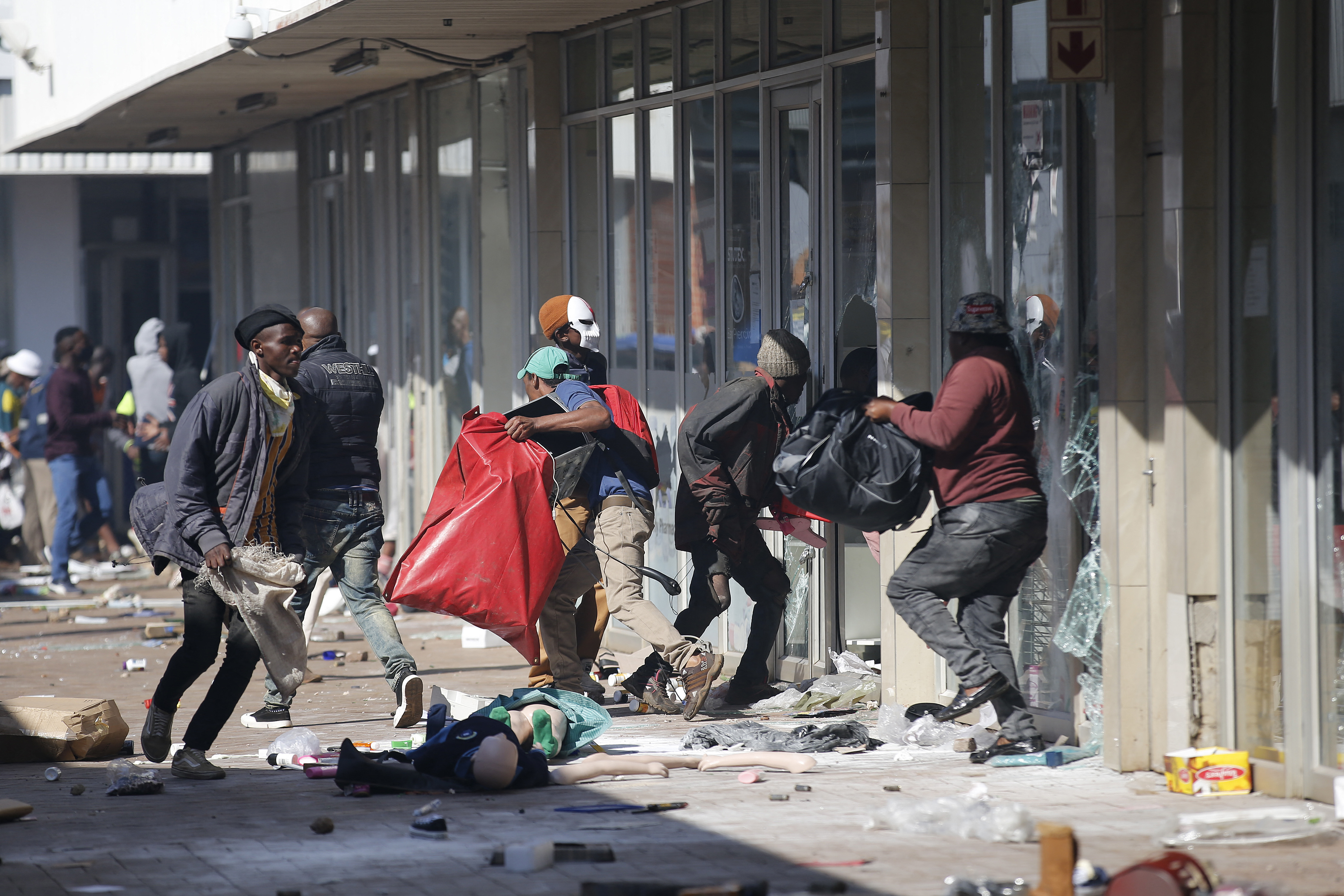 People carry goods as they loot and vandalise the Lotsoho Mall in Katlehong township, east of Johannesburg
