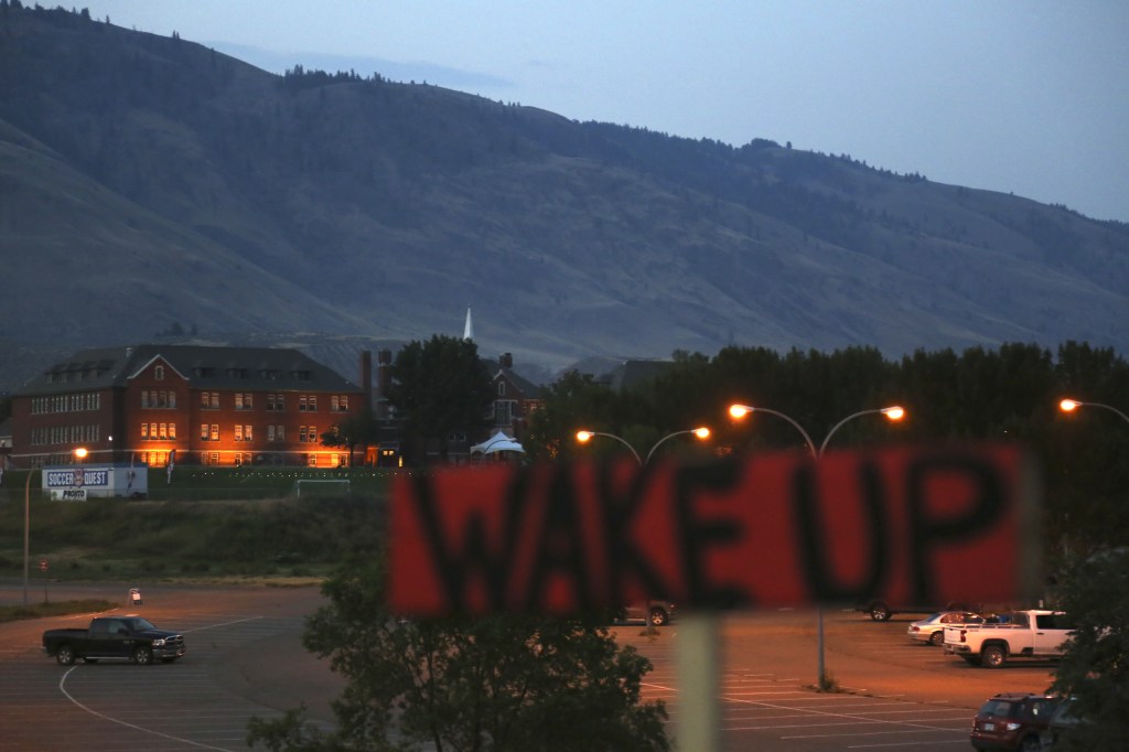 Kamloops Indian Residential School with a sign saying "wake up."