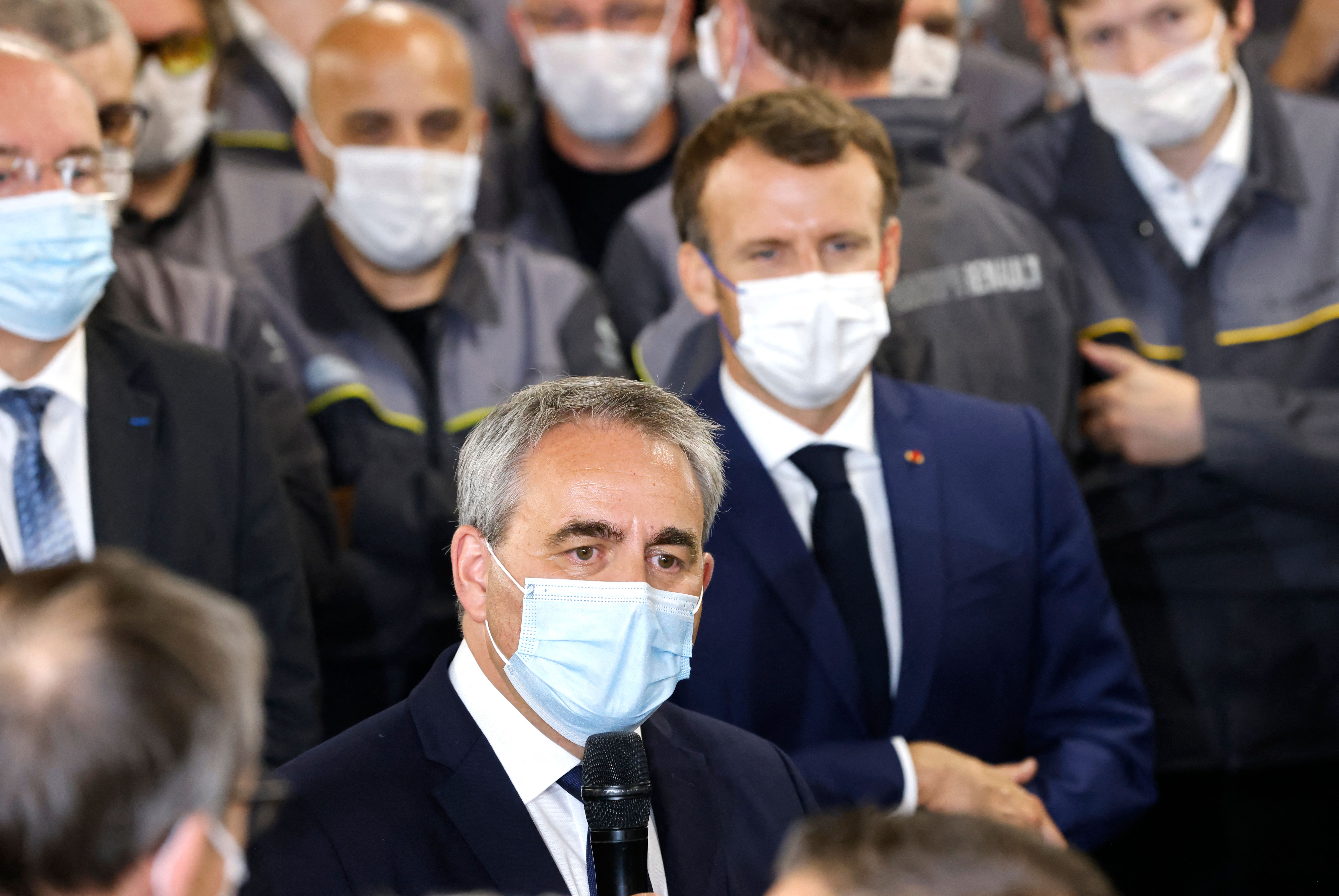 Xavier Bertrand speaks to factory workers as Emmanuel Macron looks on in the background. Photo: LUDOVIC MARIN/POOL/AFP via Getty Images