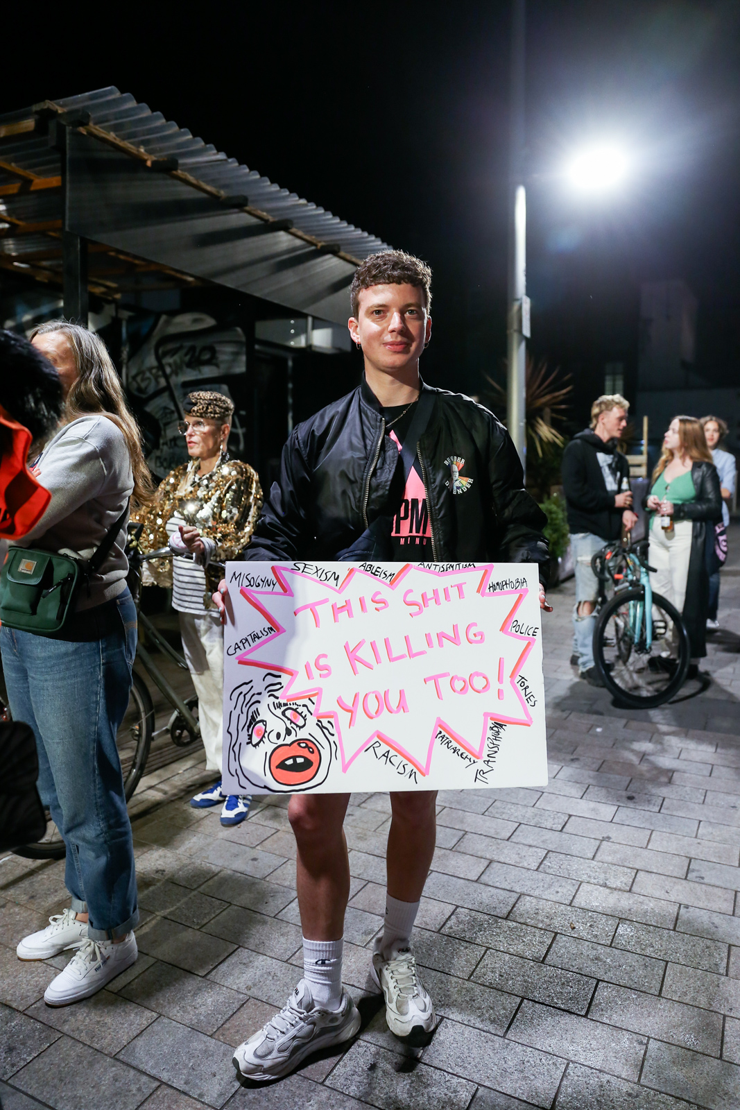 A demonstrator holds up a protest sign reading