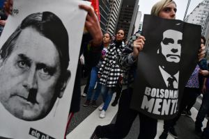Demonstrators hold signs depicting Brazilian presidential candidate Jair Bolsonaro as Adolf Hitler and reading "Bolsonaro lies" during a women protest called by a social media campaign under the hashtag #EleNao (Not Him) in Sao Paulo, Brazil, on October 6