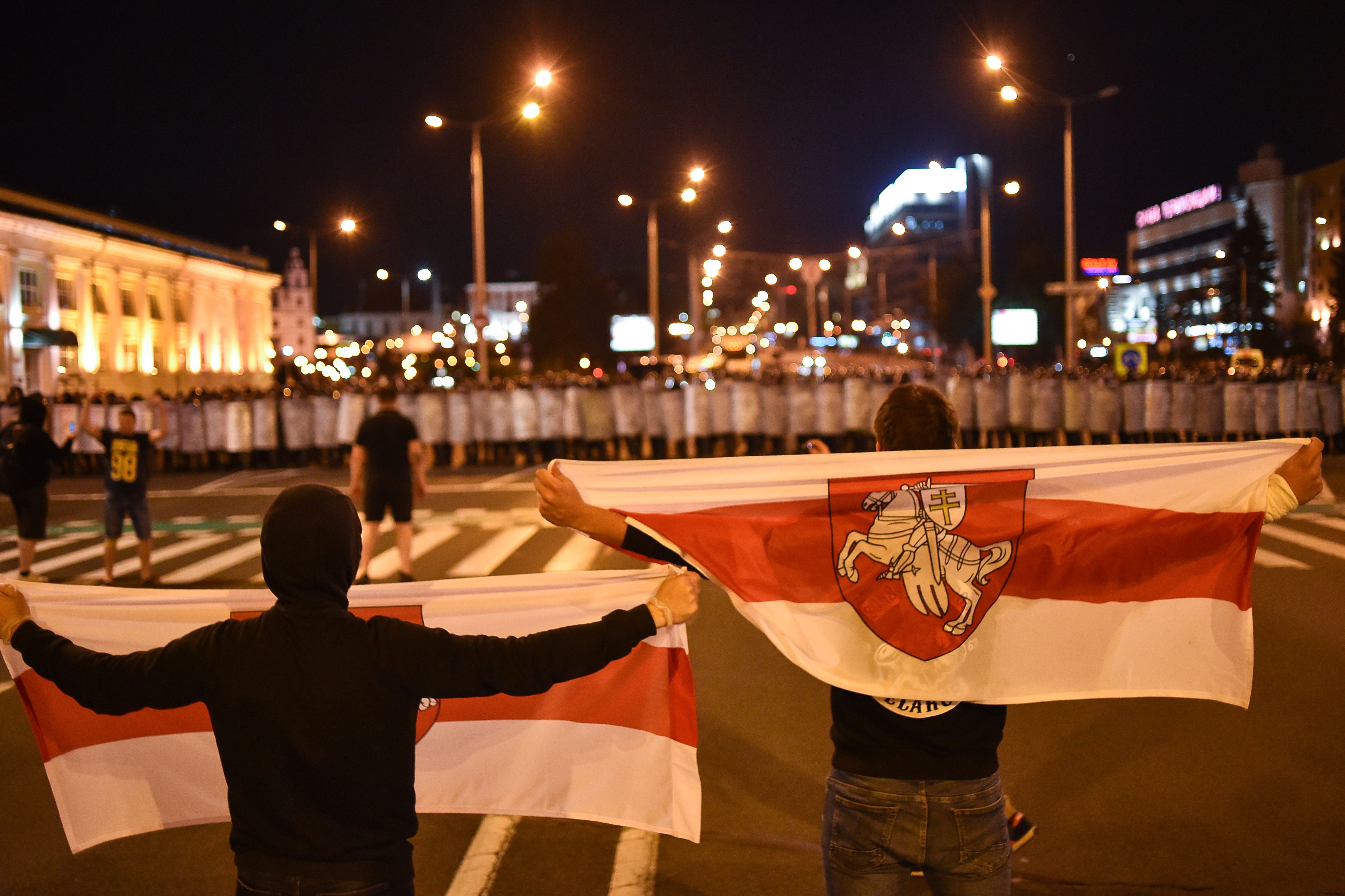 Demonstrators stand in front of riot police during a protest after polls closed in Belarus' presidential election, in Minsk on the 9th of August 2020. Photo: Sergei GAPON / AFP