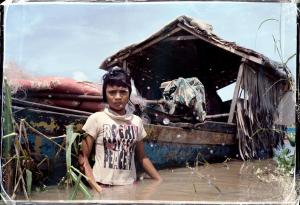 A girl and her family lives on a boat in Tonlé Sap Lake, Cambodia, which is polluted and suffering from climate change.