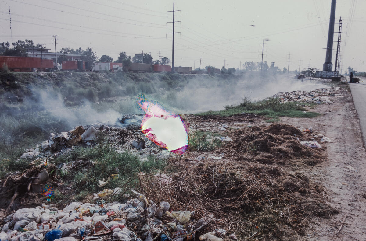 Rubbish and waste burns along the canals of Lahore, Pakistan. Image: Nad É Ali / Save the Children