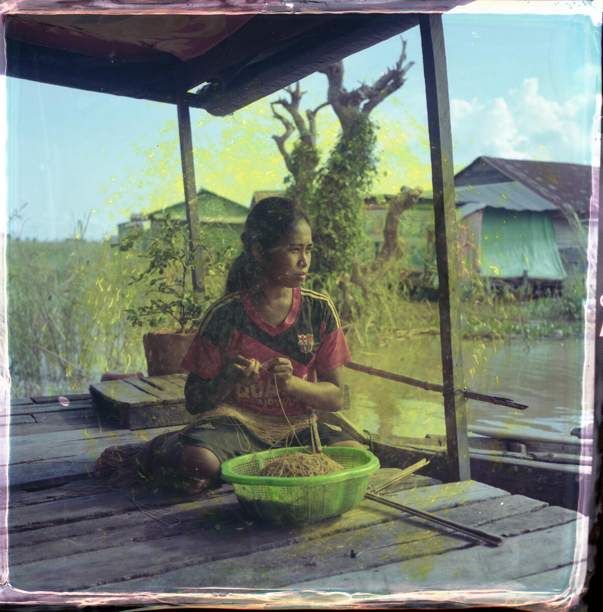 Kimsorn, 18, preparing fishing hooks for her neighbour on her floating house on Tonlé Sap Lake, Kompong Thom province, Cambodia. Image: Lim Sokchanlina / Save the Children
