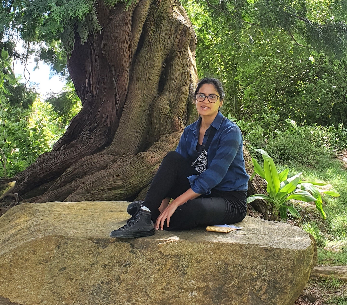 A photo of Shefali, the interviewee, sitting on a rock outdoors