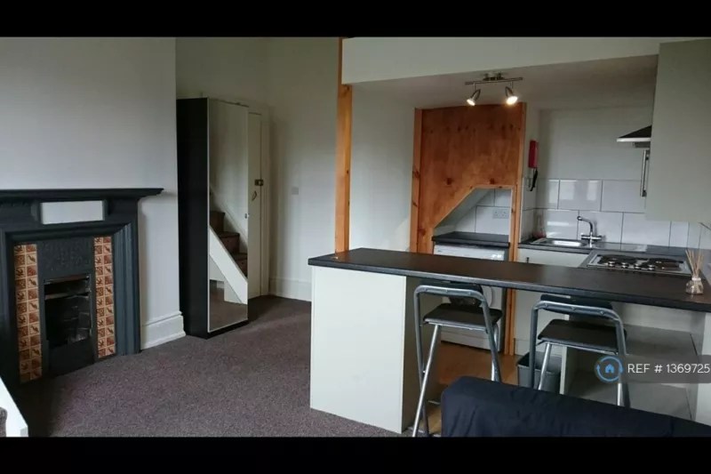 The fireplace and kitchen in a one-bed to rent Sheffield