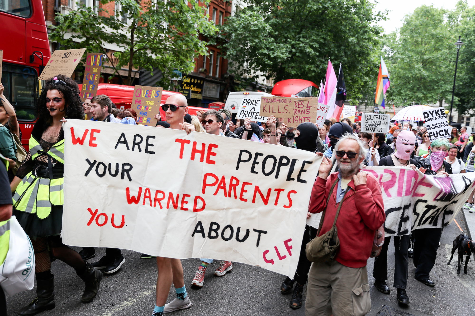 Queer people holding sign saying