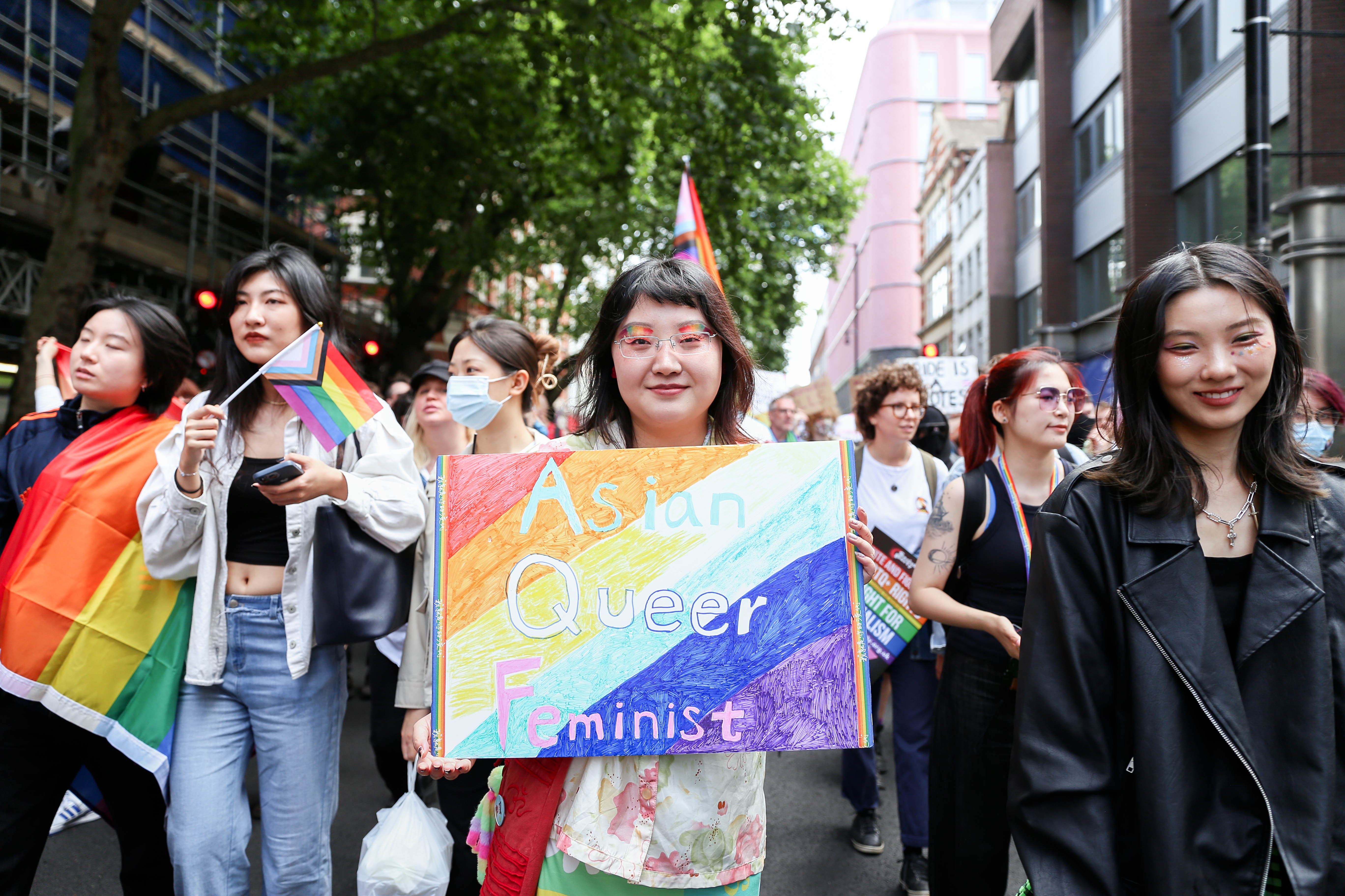 Group of Asian people holding up sign reading Asian Queer Feminist