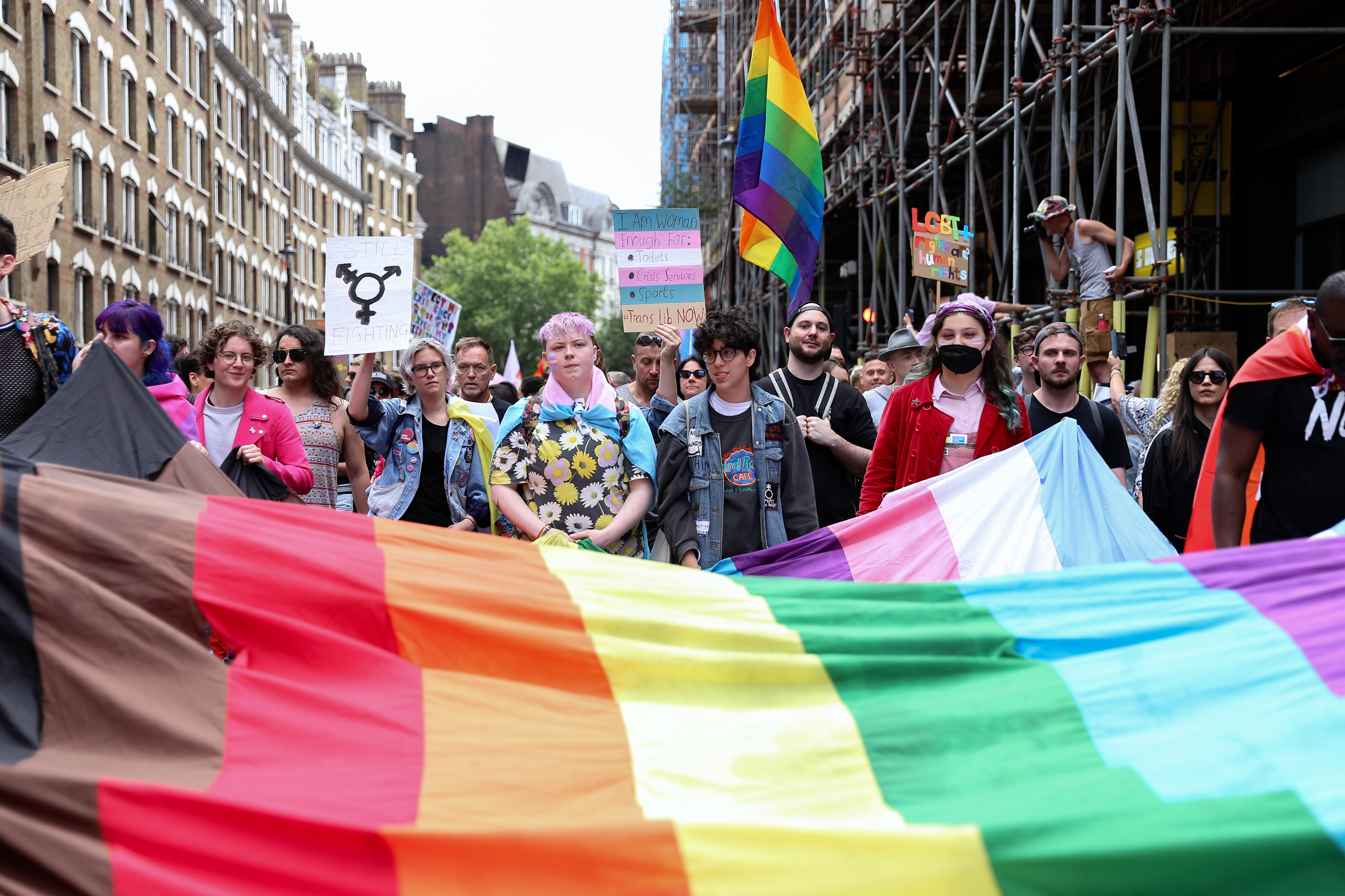 Gay Liberation Front march attendees unrolling rainbow flag