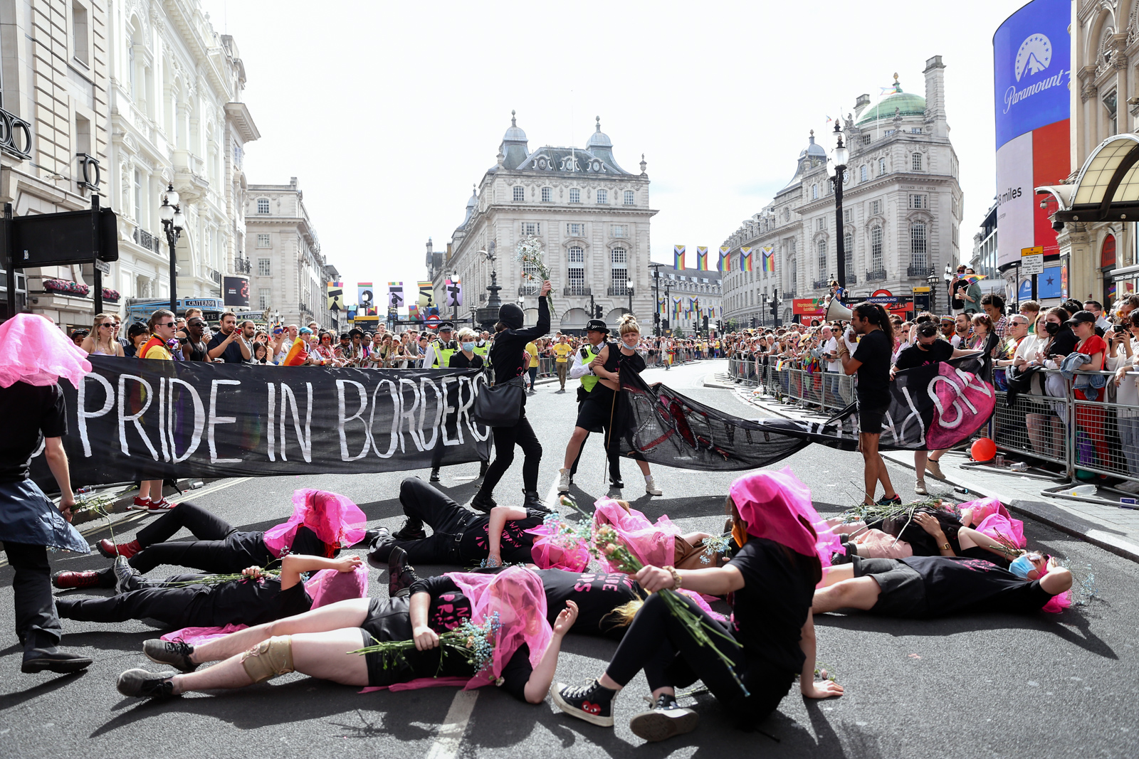 London Pride 2022: A Met Police officer holds onto a Lesbian and Gays Support the Migrants activist
