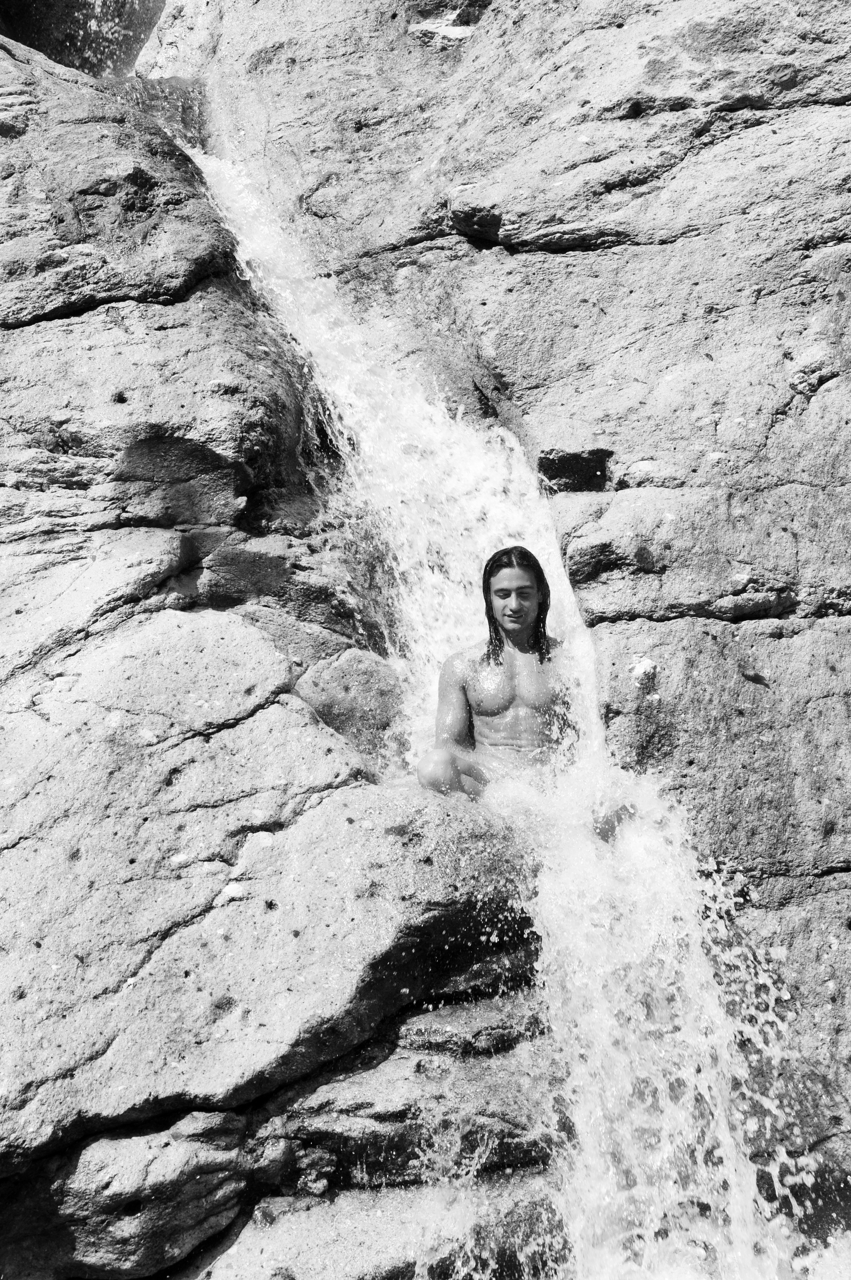 Italo Bertolasi, Italian Hippies – naked man sitting in a meditative pose underneath a waterfall