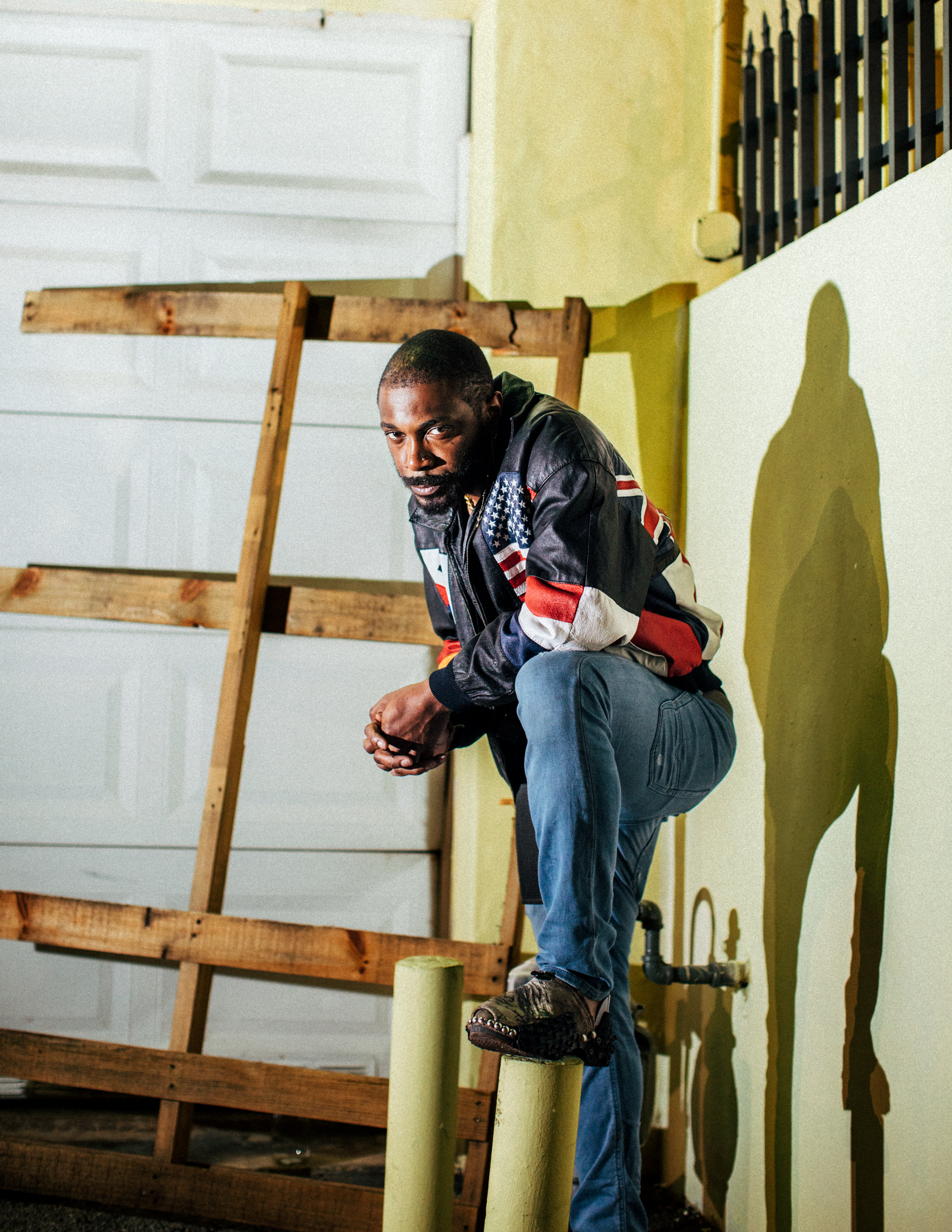 JPEGMAFIA with a foot on a bollard in an alley