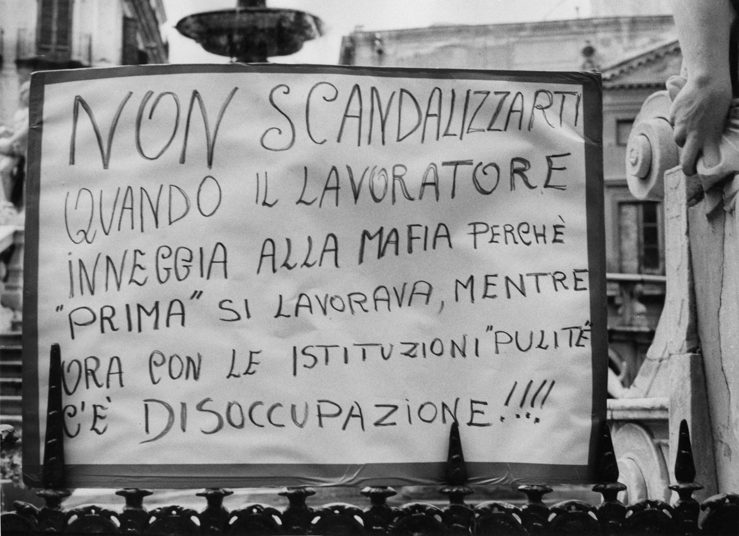 Fabio Sgroi, Seconde guerre mafieuse - gros plan sur une pancarte accrochée devant une fontaine.