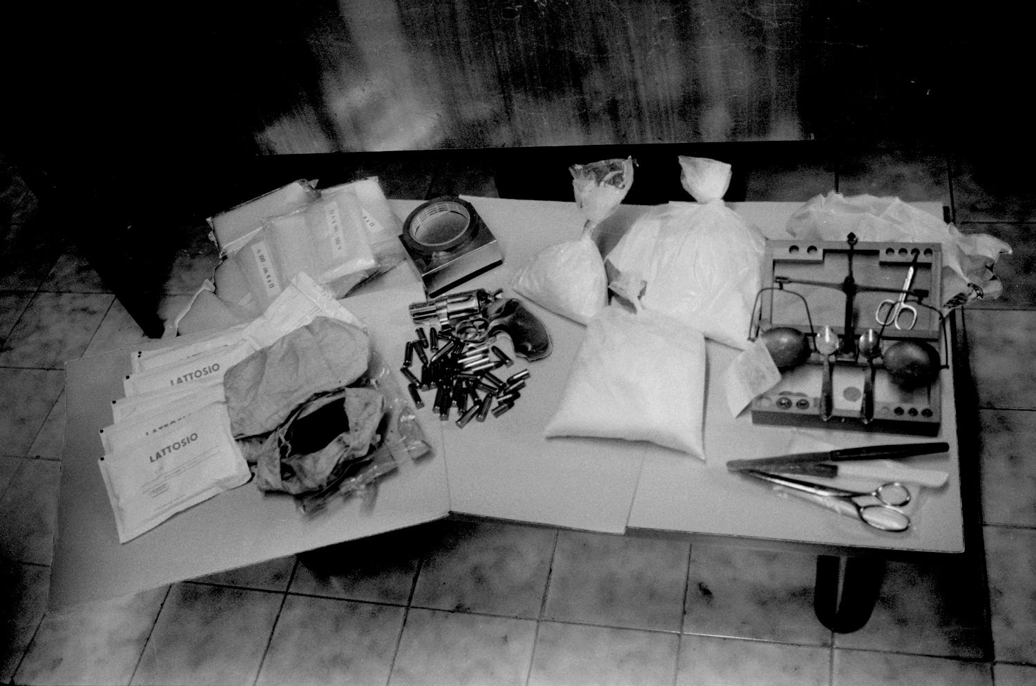 Fabio Sgroi, Seconde guerre mafieuse - Une table chargée de trois grands sacs de poudre blanche, de balles et d'autres objets.