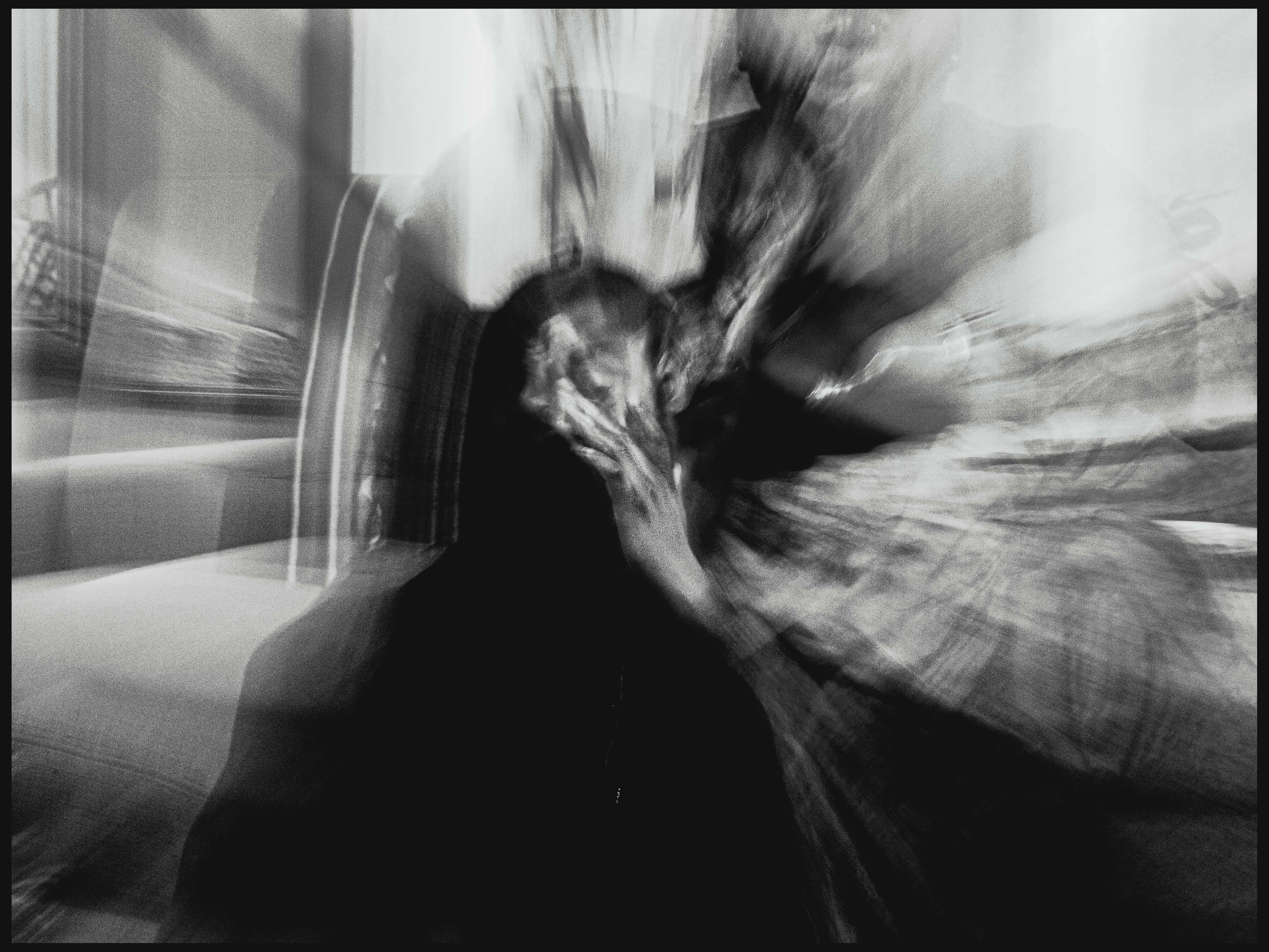 billy woods with his hand on his face, the image is blurred.