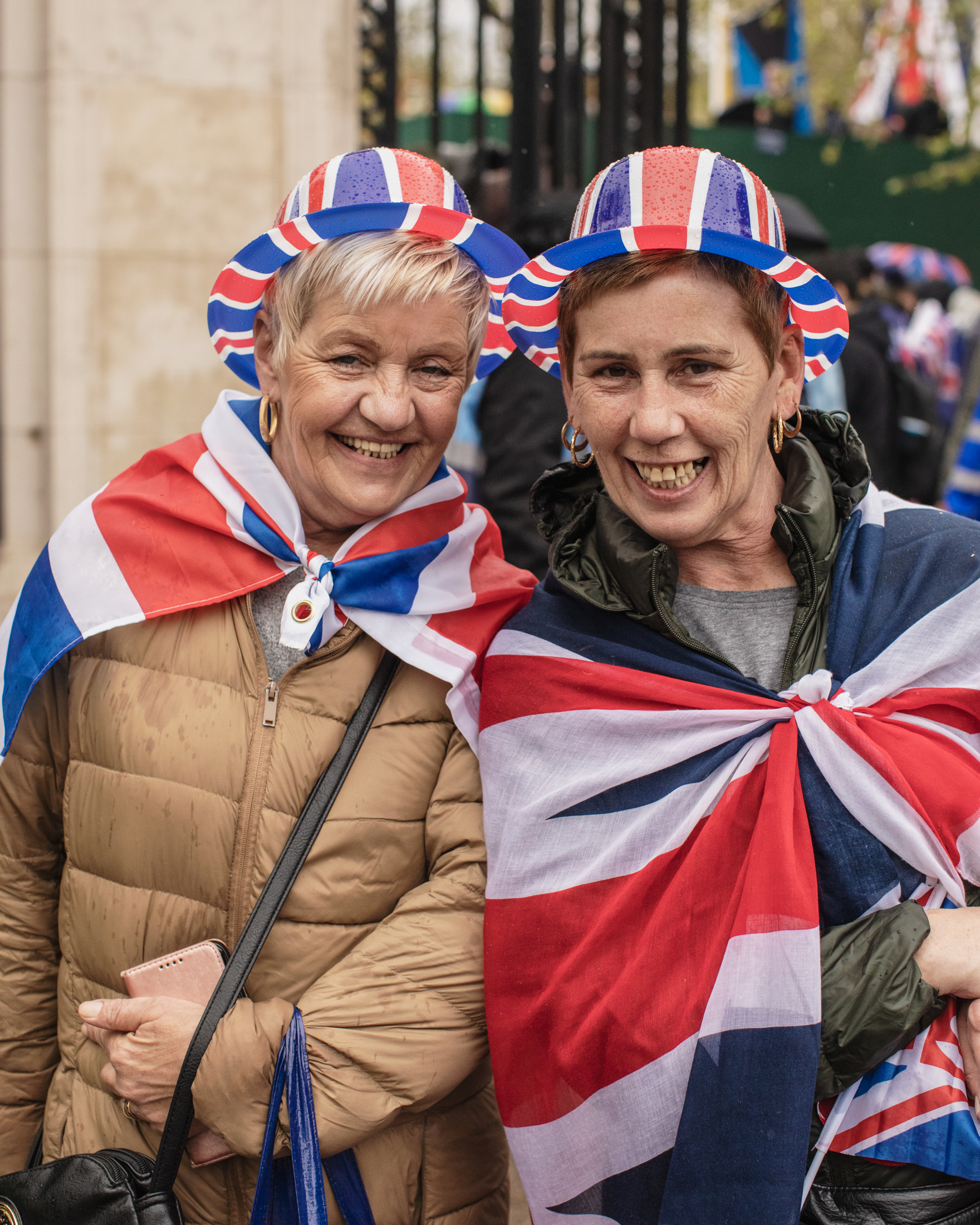 Coronation of King Charles II, London: Two women smiling in Union Jack bowler hats