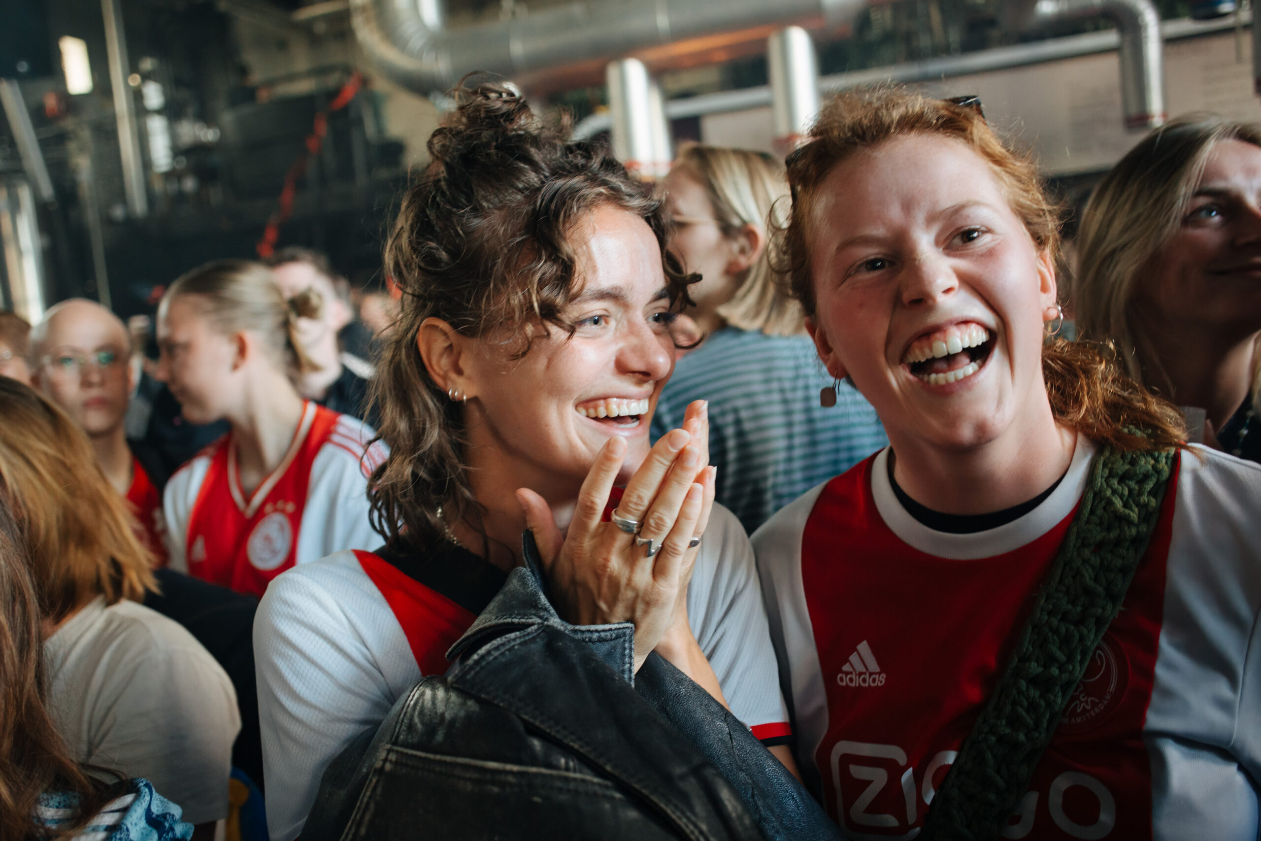 Twee Ajax-fans in Ajax-shirts lachen