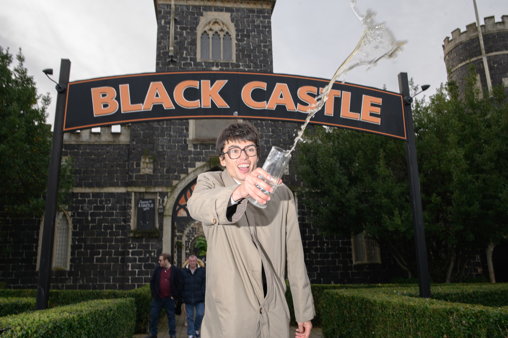 Man in glasses throwing pint outside Black Castle pub in Bristol